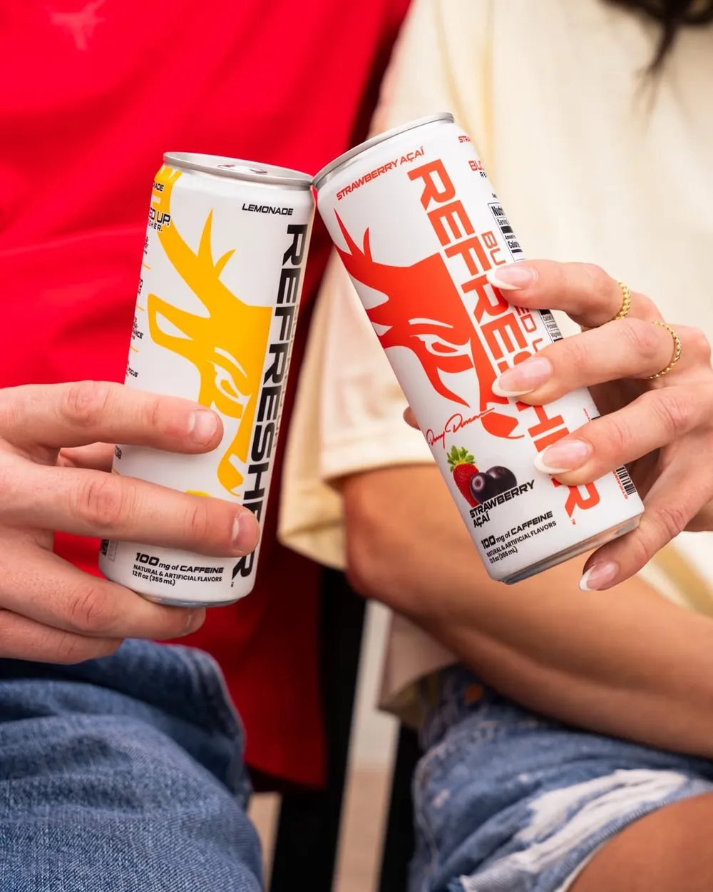 Two people cheersing with Bucked Up Refresher cans