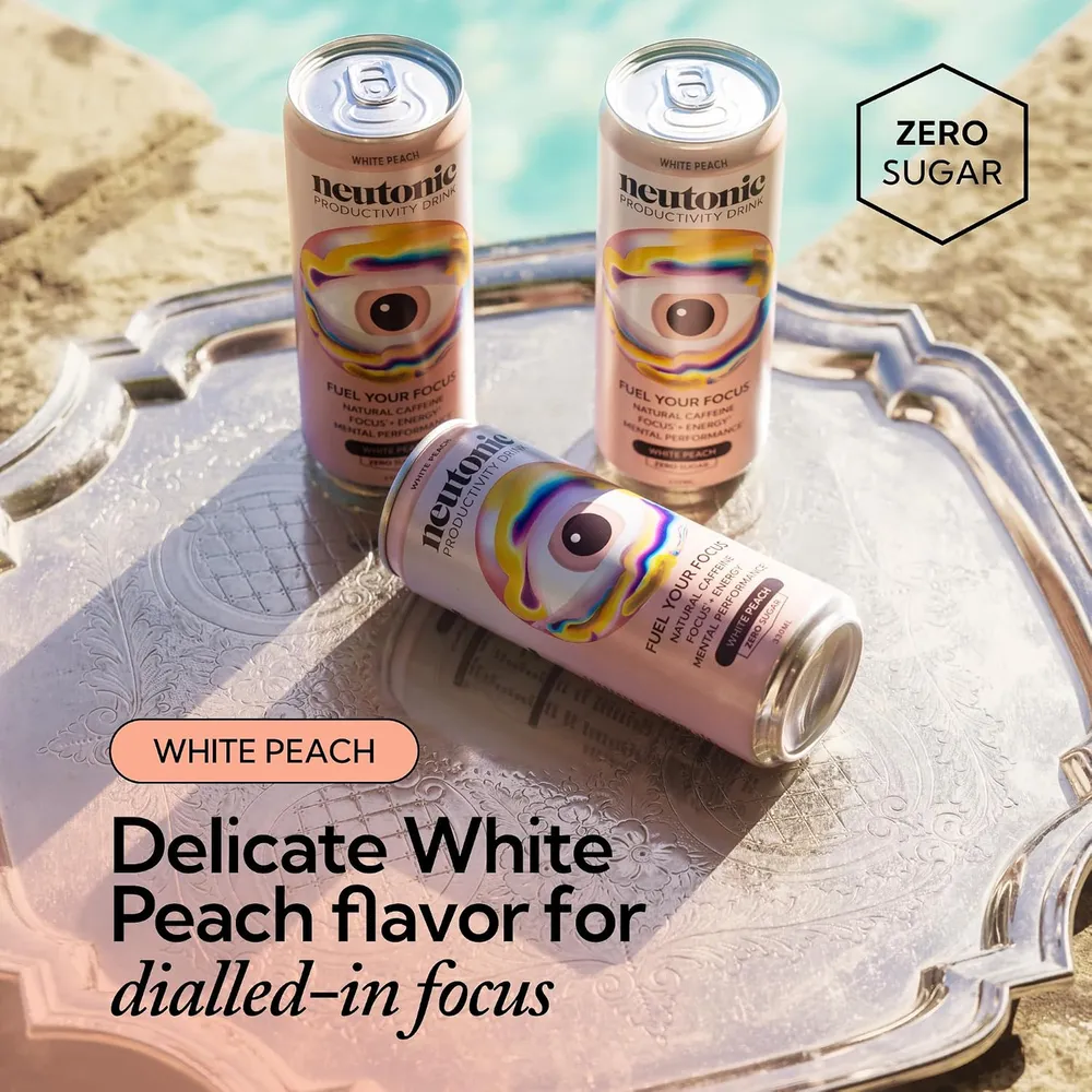 Three Neutonic White Peach cans on a silver tray by a pool, two standing and one lying on its side
