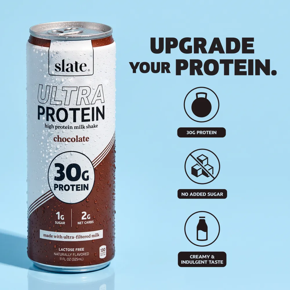 A Slate Ultra Protein chocolate shake can stands against a light blue background, with a chocolate-and-white design and prominent “30g Protein” callout