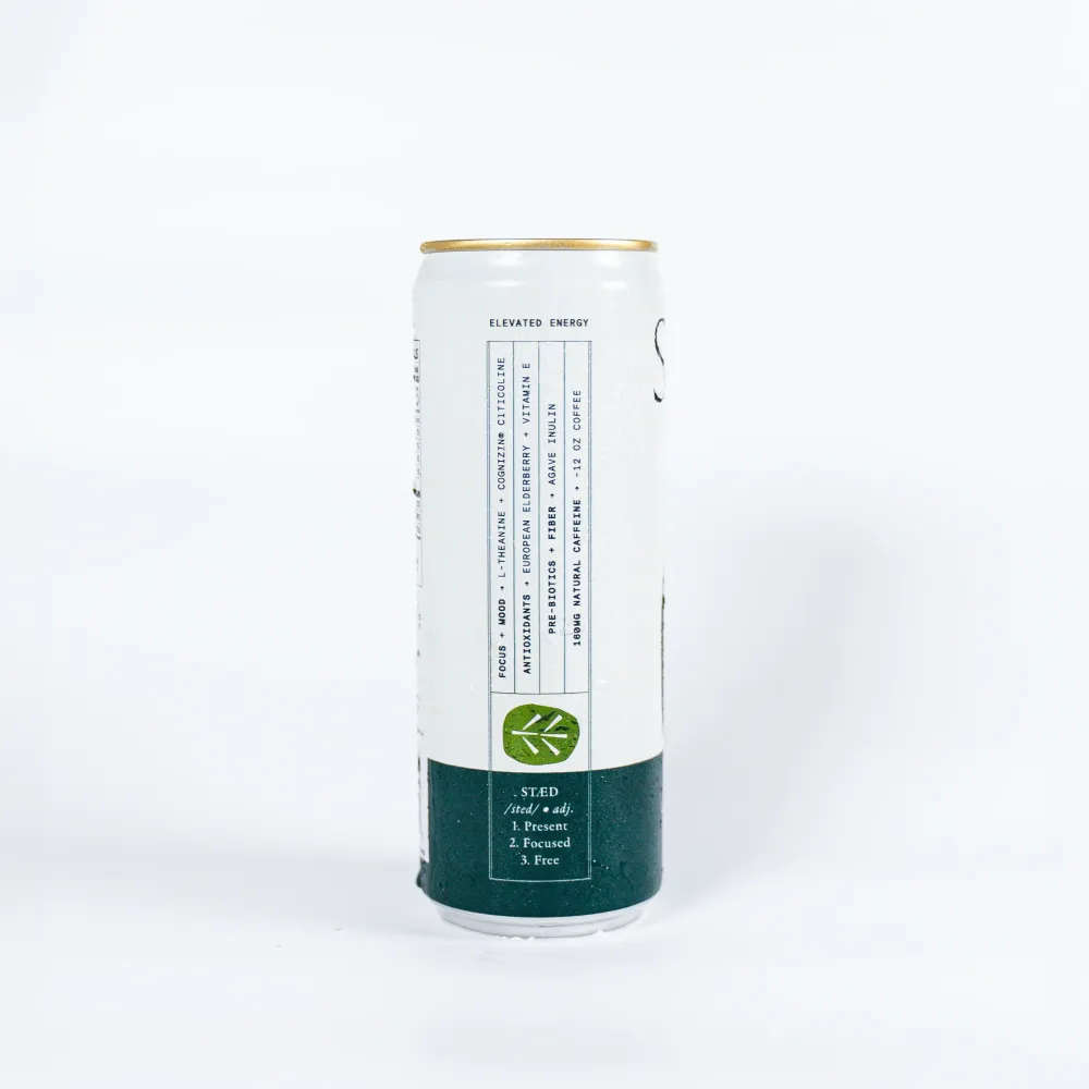 A single slim white Staed can shown upright against a plain light background, with a gold-colored rim and a dark green lower section